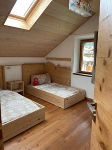 two beds in a room with wooden floors at Cèsa Cianacei Prestige in Canazei