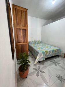 a bedroom with a bed and a plant in it at Apartamento a 5 minutos del parque principal in Jardin
