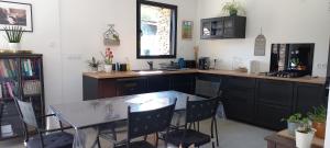 a kitchen with a table and a table and chairs at La villa du pressoir, classé 3 étoiles meublé de tourisme in Le Pallet