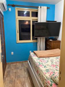 a bedroom with a bed and a flat screen tv at Apartamento aconchegante no Hotel Quitandinha in Petrópolis