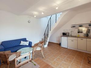 a living room with a blue couch and a kitchen at Rezidence Věstonice in Horní Věstonice