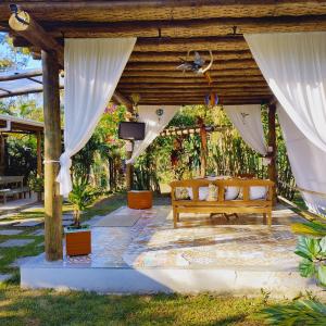 パラチにあるCamping Águas da Bocainaのパーゴラの下のテレビ付きの木製ベンチ