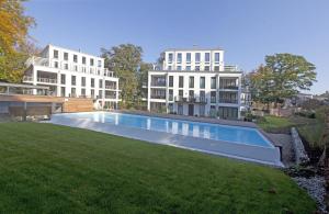 a swimming pool in a yard with two buildings at Parkvilla Mathilde - Luxus Penthouse 26 "Sea View" in Binz