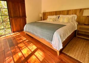 聖瑪爾塔的住宿－Solea Villa Tropical，一间卧室设有一张大床,铺有木地板