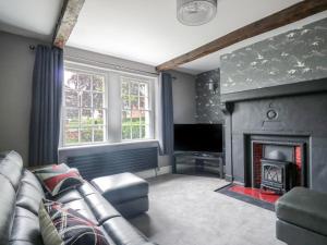 a living room with a couch and a fireplace at The Hollies in Carlisle