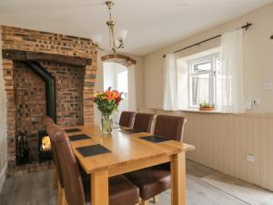 a dining room with a table and chairs and a fireplace at The Hollies in Carlisle