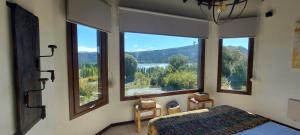 CholilaにあるLares de Yaimaのベッドルーム1室(湖の景色を望む大きな窓付)