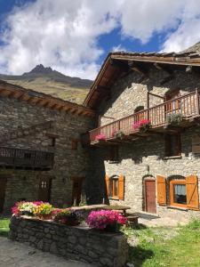 kamienny budynek z kwiatami przed nim w obiekcie Chalet 3 Céline 6 personnes Vieux Village w mieście Bonneval-sur-Arc