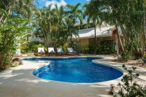 ein Pool vor einem Resort mit Palmen in der Unterkunft Boutique Surf Hotel Rip Jack Inn in Playa Grande