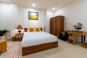 a bedroom with a bed and a table and a mirror at Shogun Hotel in Ho Chi Minh City