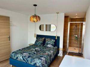 a bedroom with a bed with a blue head board at Saint-Florent, Sublime Vue Mer plage 5mn à pied in Patrimonio