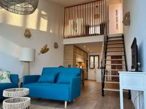 sala de estar con sofá azul y escalera en Saint-Florent, Sublime Vue Mer plage 5mn à pied en Patrimonio