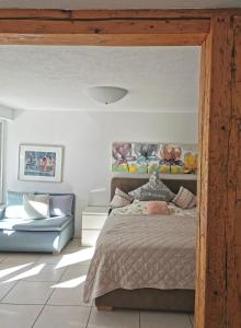 ライナウにあるFerienwohnung-Dorotheのベッドルーム(ベッド1台、青いソファ付)