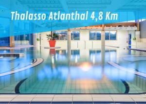 a swimming pool with the words thulsos atlantaatlantic km at Le May'Aïta - Calme, Parking & Central in Anglet