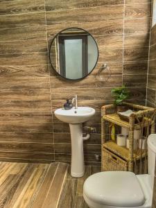 a bathroom with a sink and a mirror and a toilet at Cozy minimal suite in Accra