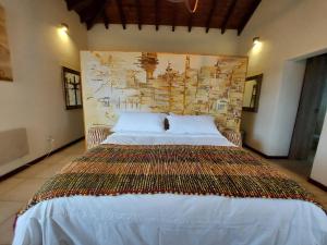 1 cama grande en un dormitorio con una pared grande en Lares de Yaima en Cholila