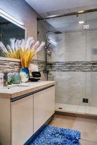 baño con ducha de cristal y alfombra azul en Luxury Apartment at 20 South, en Kingston