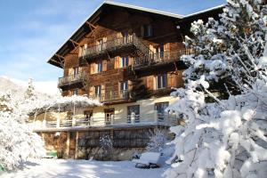 una cabaña de madera en la nieve con árboles nevados en Le Vieux Chalet, en Embrun