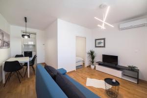 a living room with a blue couch and a table at Apartman Bauer, Zagreb in Zagreb