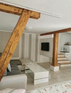 a living room with wooden beams and a tv at Ferienwohnung-Dorothe in Rheinau