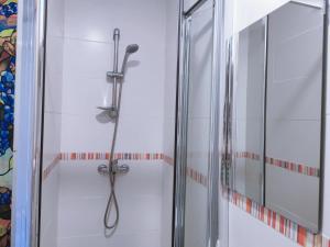 y baño con ducha y puerta de cristal. en Barcelona CoronaHostal en Badalona