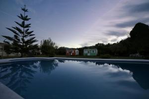 een blauw zwembad met een huis op de achtergrond bij VILLA MARINA 4 in Los Barrios