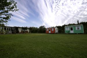 un campo verde con dos casas y un cielo nublado en VILLA MARINA 4, en Los Barrios