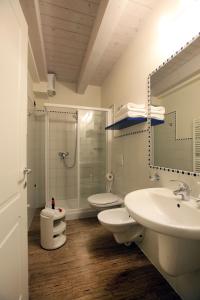 een badkamer met 2 wastafels, een douche en een toilet bij Corte San Luca Apartments in Bardolino