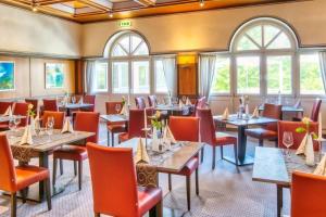 un restaurant avec des tables, des chaises et des fenêtres dans l'établissement Hotel Sonnengarten, à Bad Wörishofen