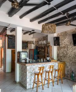 un restaurant avec un bar doté de tabourets orange dans l'établissement Casa Zahri Boutique Hostel, à Carthagène des Indes