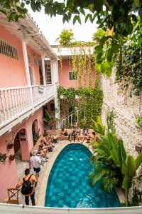 un grupo de personas sentadas alrededor de una piscina en un edificio en Casa Zahri Boutique Hostel, en Cartagena de Indias