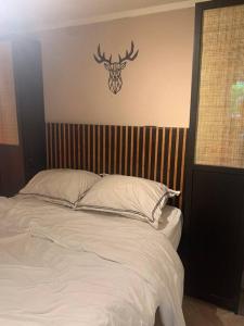 um quarto com uma cama com uma cabeça de veado na parede em Veluws BOHO huis in de natuur em Putten