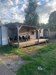 uma casa com um alpendre com mesas e cadeiras em Veluws BOHO huis in de natuur em Putten