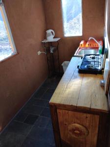a small kitchen with a stove and a sink at Hermosa cabaña para 4 personas con tinaja-Cochiguaz Valle de Elqui in Monte Grande