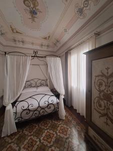 a bedroom with a bed with a canopy and curtains at Palazzo Guajana in Trapani