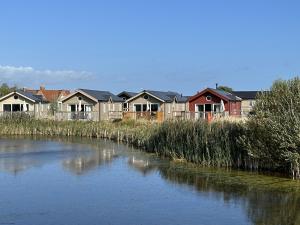 a row of houses next to a river at Low Lake Lodge - Lakeside - Part of the The Bay Filey Holiday Village with pool, gym and direct beach access, pub, restaurant, tennis and meadows walks in Reighton