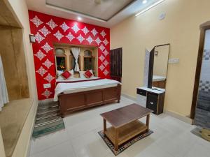 1 dormitorio con cama y pared roja en Hotel Golden Night Jaisalmer en Jaisalmer