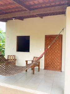 a hammock in a room with a tv and a tv at Chalé Sol in Pacoti