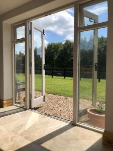 an open sliding glass door with a view of a yard at Stylish Barn Conversion with Woodland Views in Newark-on-Trent