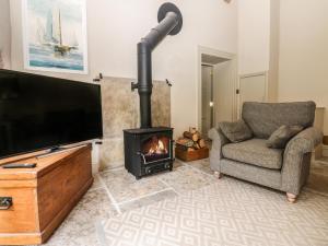 a living room with a fireplace and a television at The Courtyard in Carlisle