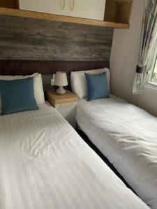 two beds sitting next to each other in a room at Splendid View Caravan in Gisburn