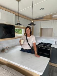a woman standing at a counter in a kitchen at Splendid View Caravan in Gisburn