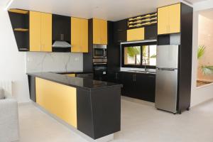 eine Küche mit gelben und schwarzen Schränken in der Unterkunft DIAR SIDI VILLAS DE LUXE in Kelibia