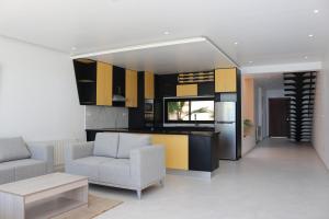sala de estar con 2 sillas y cocina en DIAR SIDI VILLAS DE LUXE, en Kelibia