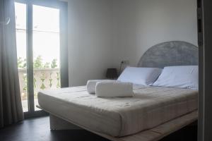 1 dormitorio con 1 cama grande y ventana grande en Hostal Bon Sol en Sant Ferran de Ses Roques