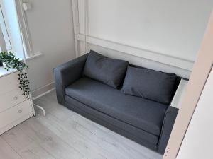 un divano blu in una stanza con un muro di Cozy room with smart solutions Grunerløkka Central a Oslo