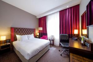 Cette chambre comprend un lit, un bureau et une télévision. dans l'établissement DoubleTree by Hilton Hotel London - Marble Arch, à Londres