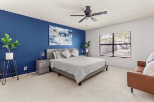 een blauwe slaapkamer met een bed en een plafondventilator bij SeaCasa San Antonio in San Antonio