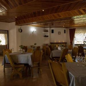 een eetkamer met 2 tafels en stoelen en een tafeltennistafel bij Vila katherina in Moieciu de Sus