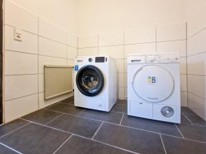 eine Waschmaschine und einen Trockner in einem Zimmer in der Unterkunft RAJ Living - 6 Room House with Terrace and Parking - 30 Min Messe DUS in Mönchengladbach